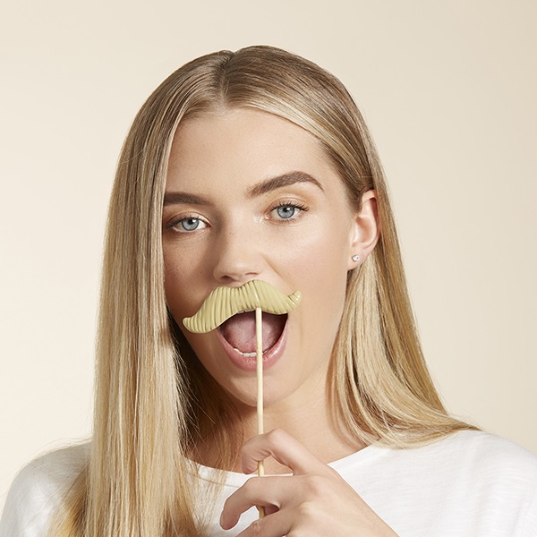 Blonde waman holding moustache prop to face