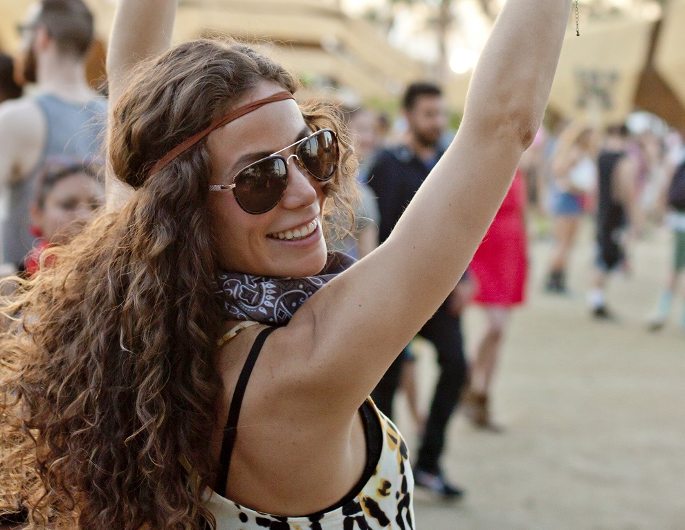 Young woman making peace signs at a music festival.