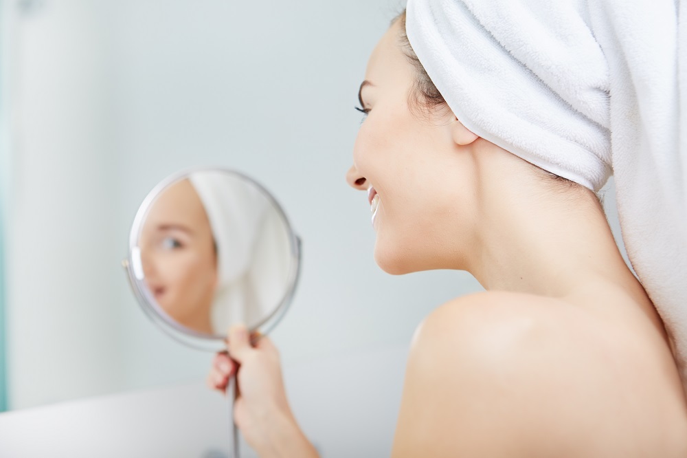 face of young beautiful healthy woman and reflection in the mirror