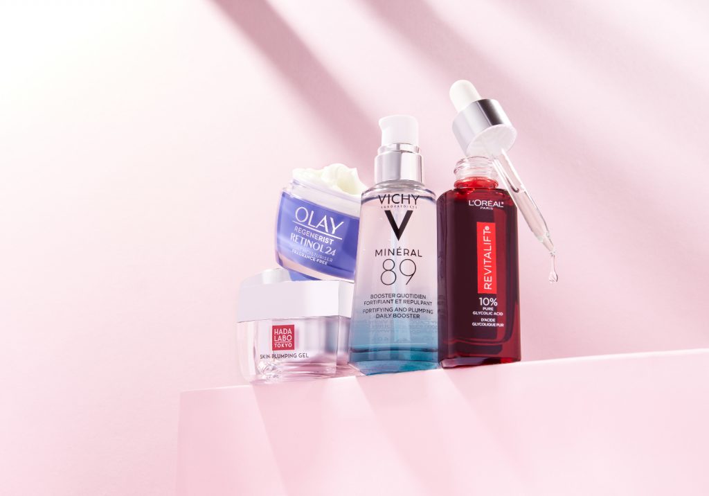 Loreal and other brands face serums and creams pink background