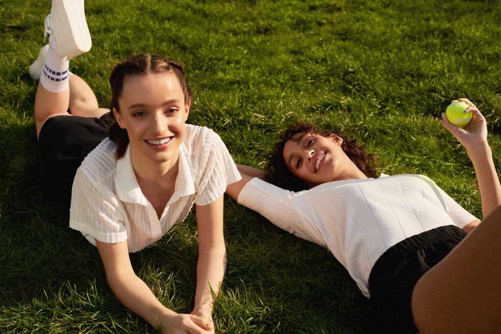 two young girls laying in the grass 