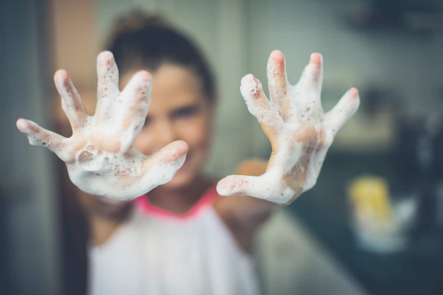 A little girl with soapy hands