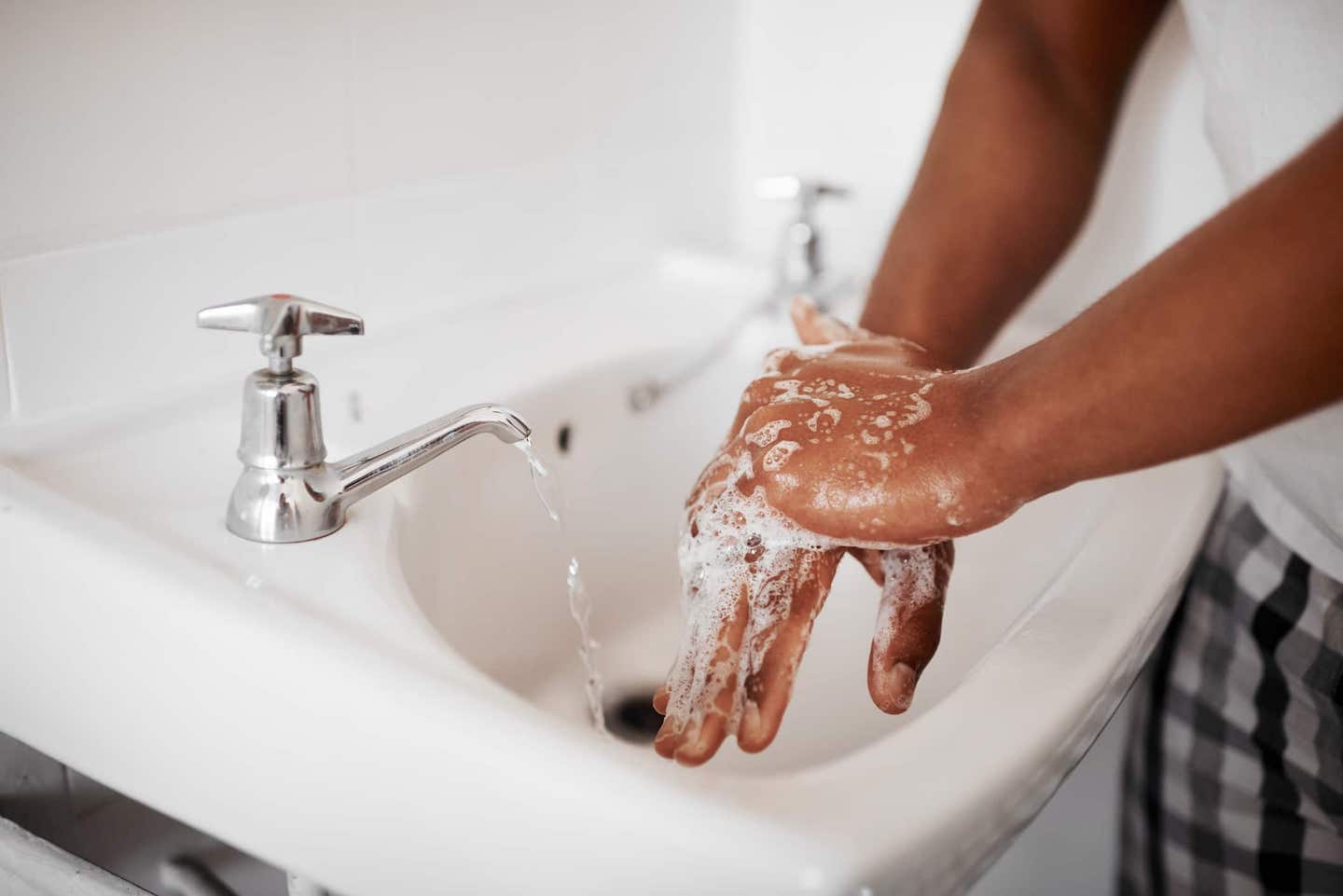 A man washing his hands with soap at home