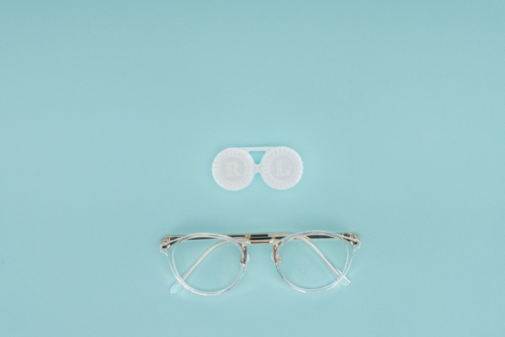 Glasses and Contact Lens Case on Blue Background