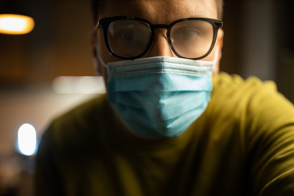 Male wearing face mask and glasses which are foggy