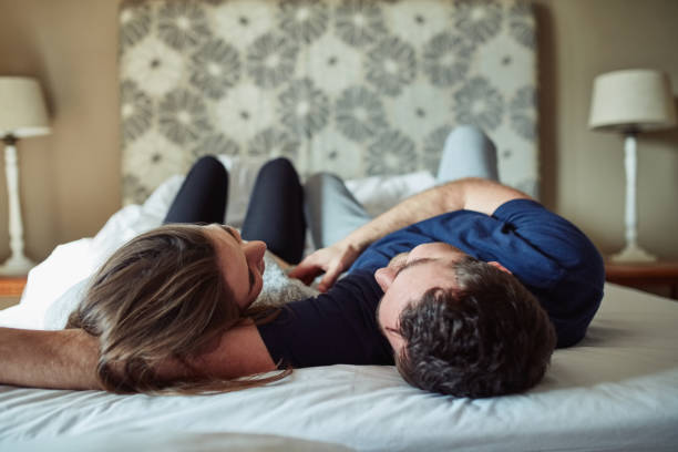 Consent blog with a picture of a happy young couple sharing a romantic moment in the bedroom at home.