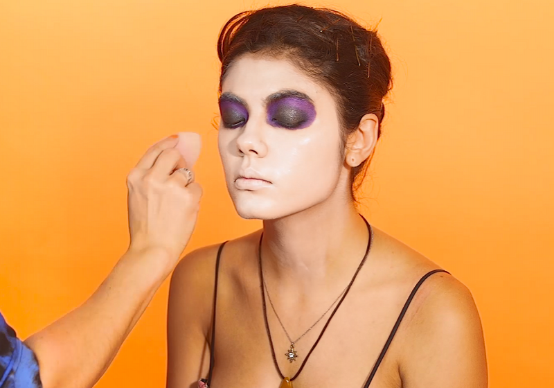 MUA applying white powder to model's face