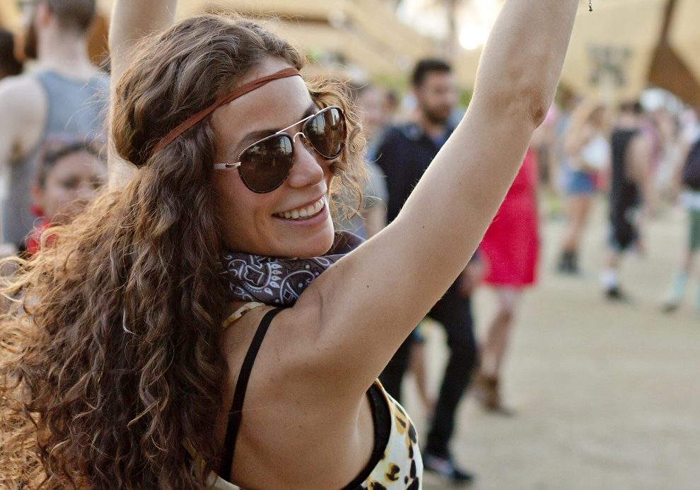 Young woman making peace signs at a music festival.