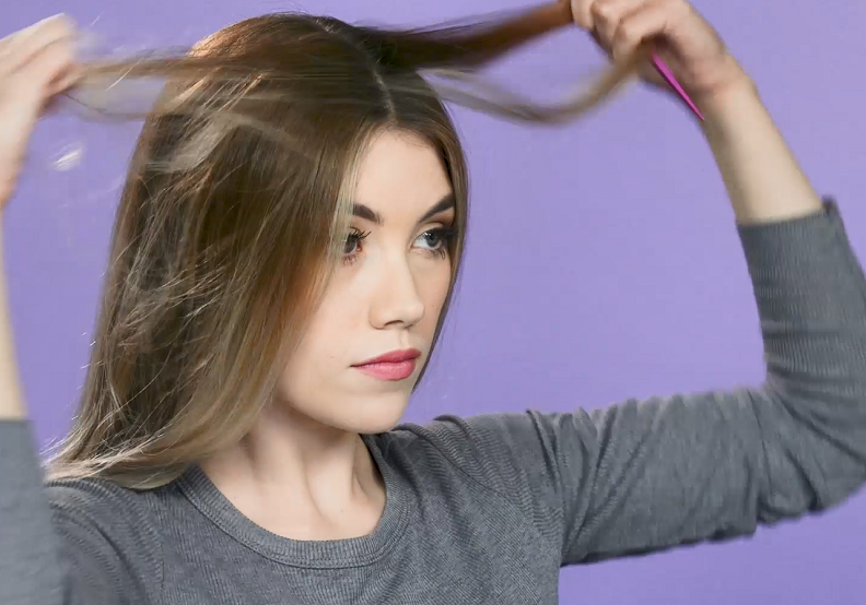 Woman sectioning hair into centre parting