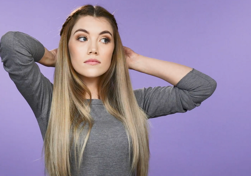 Woman styling hair into braids