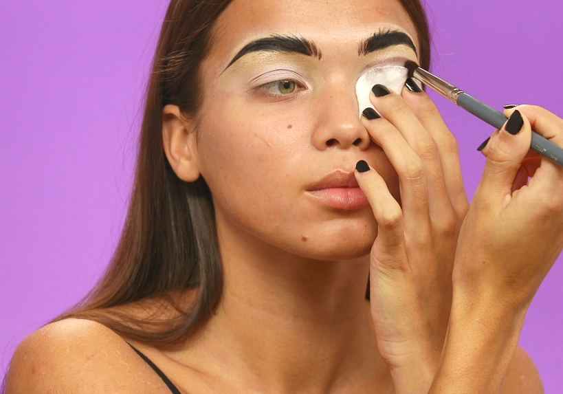 Model creating a smokey eye with eyeshadow