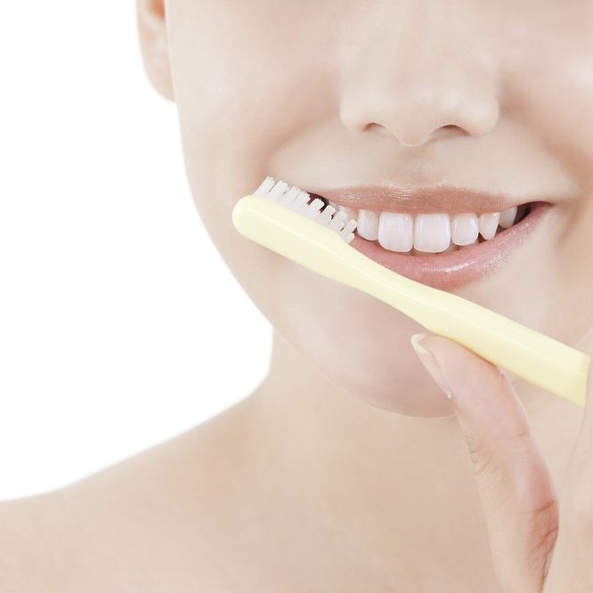 woman using toothbrush on lips